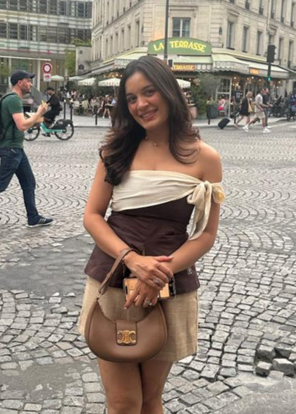Woman posing on a city street with classical architecture